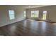 Spacious living room with hardwood floors, three windows, and a glass-paneled door, providing ample natural light at 52 Commons Cir, Clayton, NC 27520