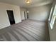 Large carpeted main bedroom with neutral walls, natural light and open entryways to closets at 52 Commons Cir, Clayton, NC 27520