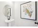 Elegant powder room with pedestal sink, oval mirror, and artistic leaf print at 52 Commons Cir, Clayton, NC 27520