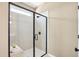 Walk-in shower with frameless glass door, bench, and neutral-toned tile at 52 Commons Cir, Clayton, NC 27520