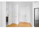 Hallway with modern doors and hardwood floors, leading to a glimpse of the adjacent kitchen at 523 S West St # 409, Raleigh, NC 27601