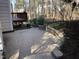 Back patio with a retaining wall and stairs leading to a raised deck at 6 Hurdle Ct, Durham, NC 27713