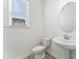 Stylish half-bath featuring a pedestal sink, modern fixtures, and a window for natural light at 652 Marion Hills Way, Knightdale, NC 27545