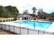 View of the community pool with a fenced perimeter and community house at 652 Marion Hills Way, Knightdale, NC 27545