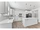 A modern kitchen with white cabinets, quartz countertops, and stainless steel appliances at 652 Marion Hills Way, Knightdale, NC 27545