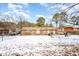 Rear exterior view of a brick home with a spacious backyard covered in snow at 722 Forge Rd, Durham, NC 27713