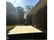 Spacious wooden backyard deck offering outdoor living space, and a red brick house with green grass at 722 Forge Rd, Durham, NC 27713