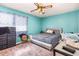 Cozy bedroom featuring a ceiling fan, a comfortable bed, and a window with patterned curtains at 722 Forge Rd, Durham, NC 27713