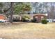Charming single-story home with a well-manicured lawn and mature trees at 722 Forge Rd, Durham, NC 27713