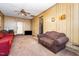 A second view of the living room with wood paneling, carpet, furniture and a television at 722 Forge Rd, Durham, NC 27713