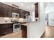 Kitchen view with stainless appliances, dark cabinets, granite counters, and wood floors at 736 Wickham Ridge Rd, Apex, NC 27539