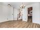 Spacious living area showcasing wood flooring, elegant chandelier, and seamless flow to kitchen at 736 Wickham Ridge Rd, Apex, NC 27539