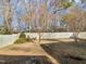 Large backyard featuring a white fence and mature trees at 8209 Rolling Glenn Dr, Raleigh, NC 27616