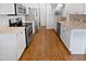 Modern kitchen with stainless appliances, white cabinets, and hardwood floors at 8209 Rolling Glenn Dr, Raleigh, NC 27616