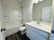 Bright bathroom with a white vanity, large mirror, and a shower-tub combo at 83 Commons Cir # 236, Clayton, NC 27520