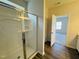 A bathroom shows a glass shower, vinyl flooring, and a door to an adjacent carpeted room at 83 Commons Cir # 236, Clayton, NC 27520