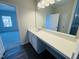 A bathroom vanity is pictured with a long mirror and a view to an adjacent carpeted room at 83 Commons Cir # 236, Clayton, NC 27520