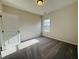 An empty bedroom features neutral walls, carpet, a window and a white door at 83 Commons Cir # 236, Clayton, NC 27520