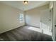 An empty bedroom features neutral walls, carpet, a window and a white door at 83 Commons Cir # 236, Clayton, NC 27520