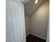 A closet with a door and dark wood-style vinyl flooring under a staircase, illuminated by a pot light overhead at 83 Commons Cir # 236, Clayton, NC 27520