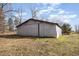 A metal barn with a sliding door and a small entrance on a grassy field with a blue sky at 8835 Us 64, Siler City, NC 27344