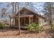 Exterior of a home with a wooden porch, mature trees, and lush foliage at 8835 Us 64, Siler City, NC 27344