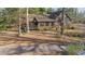 Charming two-story cabin-style home with red shutters surrounded by mature trees at 8835 Us 64, Siler City, NC 27344
