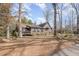 Home's exterior with large windows, a cozy porch, and mature trees at 8835 Us 64, Siler City, NC 27344