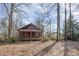 Rustic cabin with a covered front porch, nestled among mature trees and fallen leaves at 8835 Us 64, Siler City, NC 27344