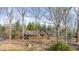 Two story cabin-style home surrounded by tall trees, a gravel driveway and lawn at 8835 Us 64, Siler City, NC 27344