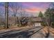 Garage on a lot with mature trees and a driveway with beautiful sunset skies at 8835 Us 64, Siler City, NC 27344