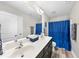 Bathroom with double sink vanity, large mirror, and blue shower curtain at 917 Sequoia Ridge Dr, Fuquay Varina, NC 27526