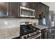 Modern kitchen with stainless steel appliances, granite countertops and dark wood cabinets at 917 Sequoia Ridge Dr, Fuquay Varina, NC 27526