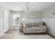 Bright living room featuring wainscoting, chandelier, and decorative wall art above a neutral sofa at 917 Sequoia Ridge Dr, Fuquay Varina, NC 27526