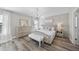 Bright main bedroom with chandelier, dresser, tufted bed, and a view to the window at 917 Sequoia Ridge Dr, Fuquay Varina, NC 27526