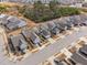 Aerial view of a new neighborhood showcasing well-maintained homes, streets, and surrounding woods at 124 Currituck Ln, Durham, NC 27703