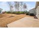 Exterior view of backyard featuring a concrete patio and a grassy area, with trees in the background at 124 Currituck Ln, Durham, NC 27703