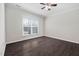 Comfortable bedroom with a ceiling fan, hardwood floors, and large window at 124 Currituck Ln, Durham, NC 27703