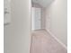 Hallway featuring neutral carpet, view into a nearby storage area, and door at 124 Currituck Ln, Durham, NC 27703