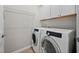 Bright laundry room with Samsung washer and dryer, overhead cabinets, and wire shelving at 124 Currituck Ln, Durham, NC 27703