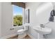 Chic powder room with a pedestal sink, round mirror, and a window offering serene outdoor views at 1259 Shaw View Alley # 201, Raleigh, NC 27601