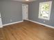 A bright bedroom with hardwood floors, neutral gray walls, and a bright window at 136 Dogwood Trl, Wendell, NC 27591