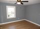 Clean bedroom with hardwood floors, a ceiling fan, and plenty of natural light from two windows at 136 Dogwood Trl, Wendell, NC 27591
