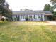 Charming single-story home with grey brick, manicured bushes, and a covered driveway at 136 Dogwood Trl, Wendell, NC 27591