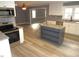 Well-lit kitchen with white cabinets, stainless steel appliances, granite countertops, and grey island at 136 Dogwood Trl, Wendell, NC 27591