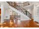 Elegant foyer with a curved staircase, hardwood floors, and decorative railings at 2012 Wide River Dr, Raleigh, NC 27614