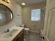 Well lit bathroom with a single sink vanity and tub with shower at 208 Lawrence Rd, Cary, NC 27511