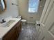 The bathroom is complete with a white toilet, shower and vanity with wooden cabinets at 208 Lawrence Rd, Cary, NC 27511