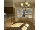 Bright dining area with chandelier and a bay window overlooking a large tree, wood floor and cream walls at 208 Lawrence Rd, Cary, NC 27511