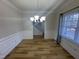 Bright dining room with wood floors, elegant wainscoting, and modern chandelier fixture at 208 Lawrence Rd, Cary, NC 27511